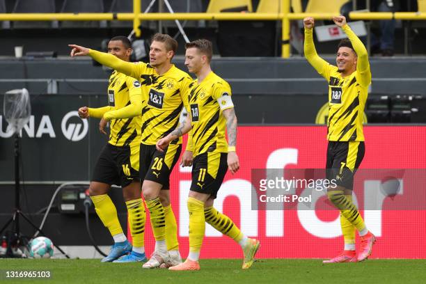 Jadon Sancho of Borussia Dortmund celebrates after scoring their team's second goal as Lukasz Piszczek and Marco Reus look on during the Bundesliga...