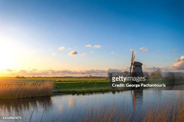 windmills next to the canal at sunset - netherlands sunset foto e immagini stock