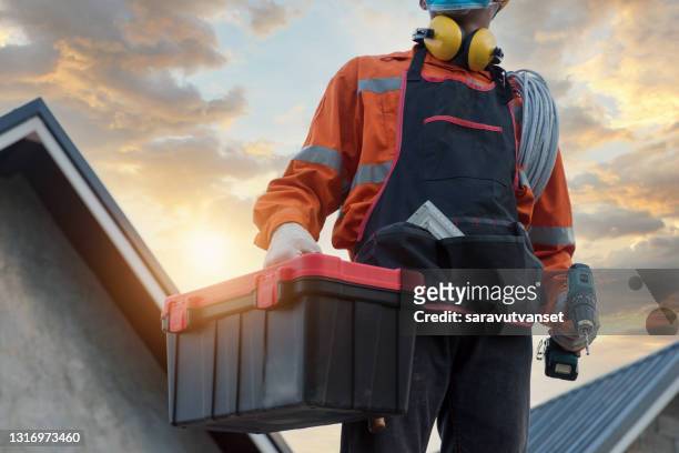 portrait of an electrician wearing a face mask carrying a toolbox, thailand - carry foundation stock-fotos und bilder
