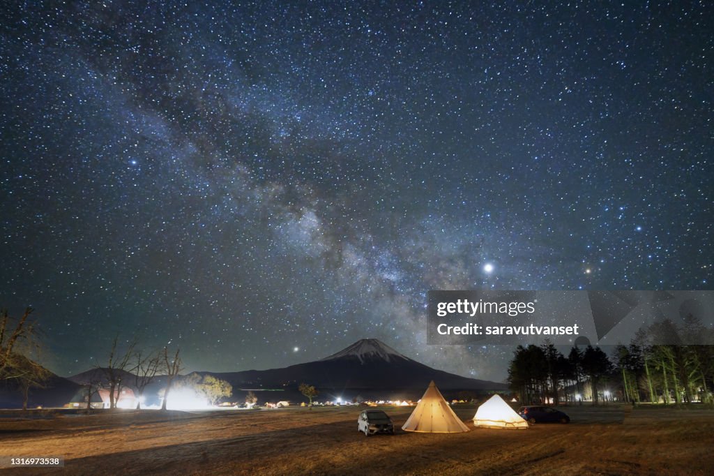Illuminated tents with Mt Fuji in the distance below the milky way, Honshu, Japan