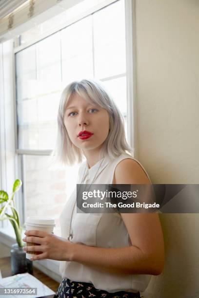 portrait of young woman with platinum blonde hair drinking coffee - platinum blonde hair stock pictures, royalty-free photos & images