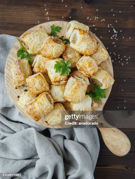 home made sausage rolls on a wooden chopping board - sausage roll stock pictures, royalty-free photos & images