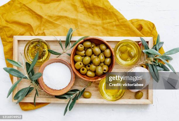 overhead view of three different pots of olive oil with olives, garlic  and seasoning on a tray - mediterraanse gerechten stockfoto's en -beelden