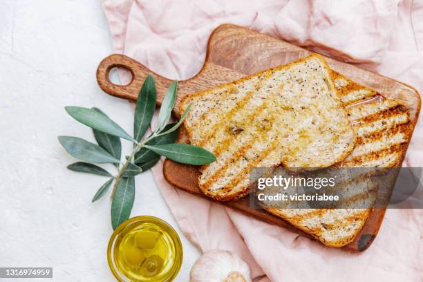 overhead view of two slices of ciabatta toast with olive oil and fresh garlic - ciabatta fotografías e imágenes de stock