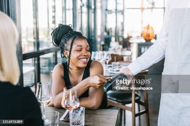 happy african american woman using credit card - restaurant atmosphere stock pictures, royalty-free photos & images