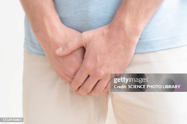 man clutching his crotch - genitalien stockfoto's en -beelden