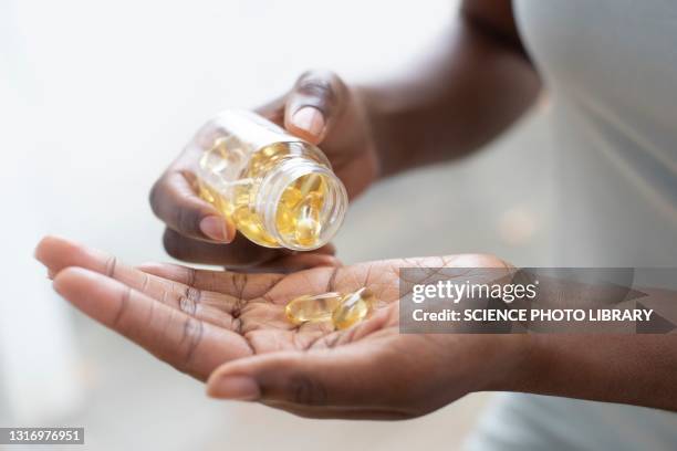 pouring capsules into hand - nutritional supplement fotografías e imágenes de stock