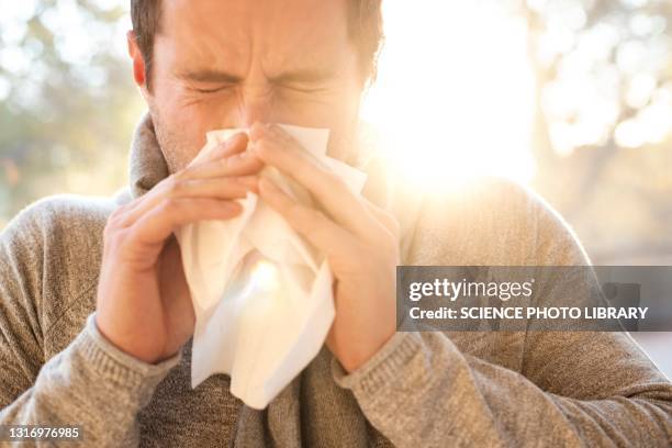man blowing his nose - allergie photos et images de collection