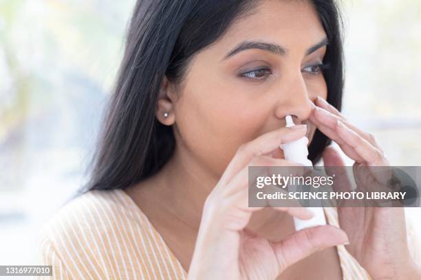 woman using a nasal spray - sinusitis stockfoto's en -beelden