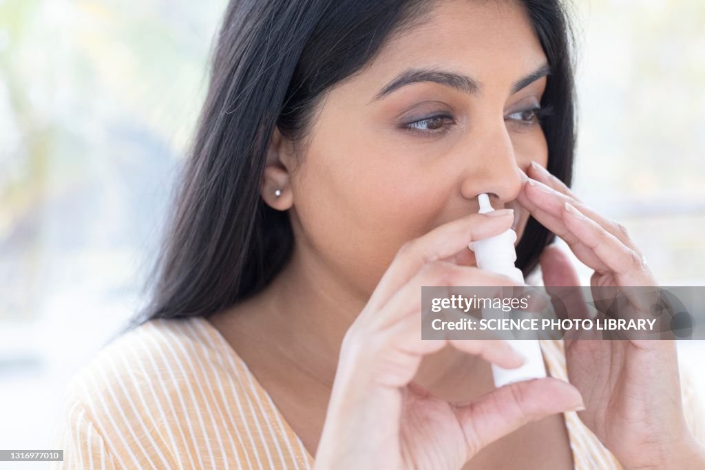 Woman using a nasal spray