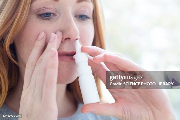woman using a nasal spray - nasal spray stock pictures, royalty-free photos & images