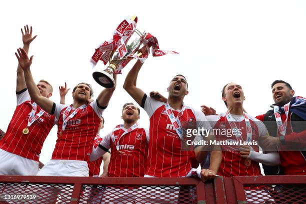 Liam Sercombe of Cheltenham Town lifts the Sky Bet League 2 Trophy as he team mates celebrate in front of fans outside the ground after the Sky Bet...