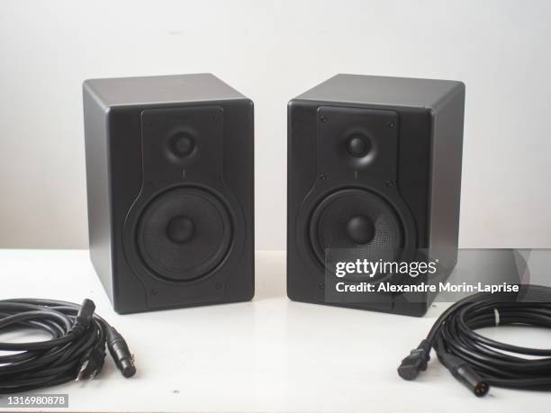 black pro studio speakers with cables against a white and gray surface - hi fi foto e immagini stock