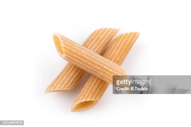 wholemeal pasta penne as close-up shot isolated on white background - whole wheat penne pasta stock pictures, royalty-free photos & images
