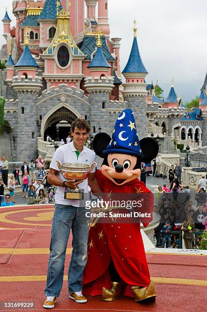 Rafael Nadal poses with the Roland Garros French Tennis Open trophy and Micky Mouse during a photocall at Disneyland Hotel on June 6, 2011 in Paris,...