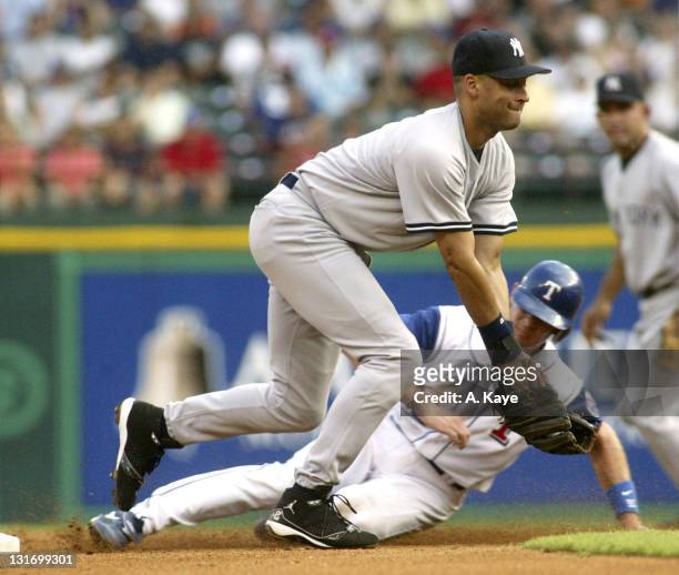 Short stop Michael Young of the Texas Rangers beats the throw from catcher Jorge Posada of the New York Yankees and slides in safely under short stop...
