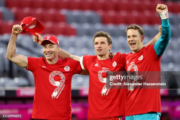 Robert Lewandowski, Thomas Mueller and Manuel Neuer of FC Bayern Muenchen celebrates winning the Bundesliga title after the Bundesliga match between...