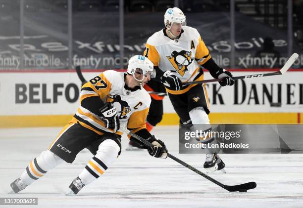 Sidney Crosby of the Pittsburgh Penguins skates the puck with Evgeni Malkin against the Philadelphia Flyers at the Wells Fargo Center on May 3, 2021...