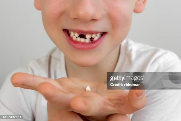 close up of a milk tooth held in the hand of a child. loss of primary teeth, smiling baby - losing virginity stock pictures, royalty-free photos & images