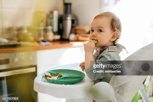 söt liten flicka som äter måltid vid barnstol - baby eating bildbanksfoton och bilder