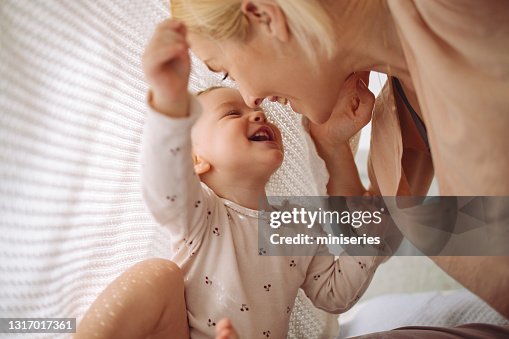 Loving mother and daughter playing under blanket Loving mother and daughter playing under blanket
