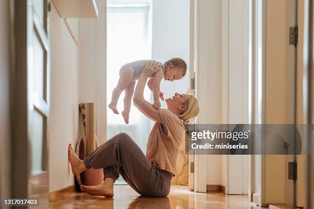 speelse moeder en babydochter thuis - learning to walk stockfoto's en -beelden