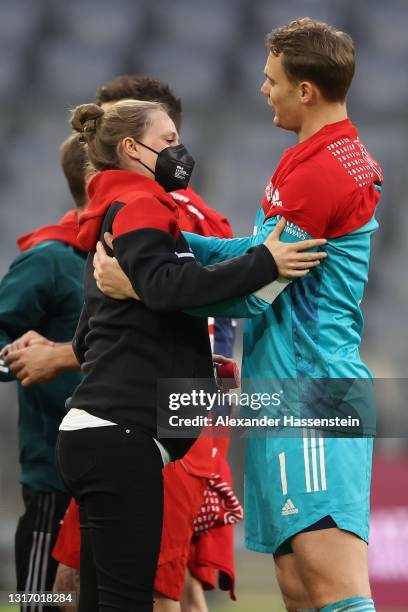 Manuel Neuer of FC Bayern Muenchen celebrates winning the Bundesliga title with team manger Kathleen Krüger after the Bundesliga match between FC...