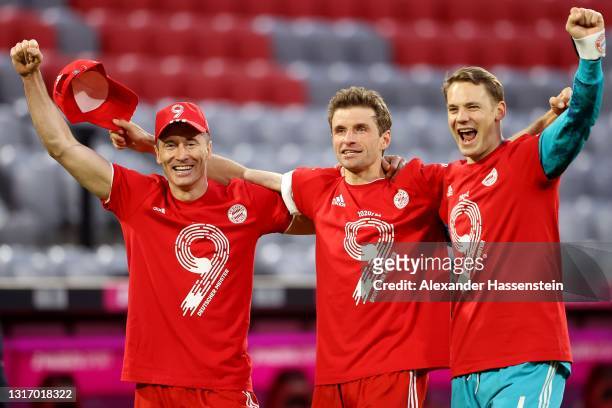 Robert Lewandowski, Thomas Mueller and Manuel Neuer of FC Bayern Muenchen celebrates winning the Bundesliga title after the Bundesliga match between...