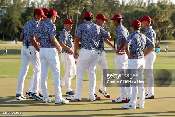Austin Eckroat of Team USA celebrates with teammates on the 18th green after winning his match against Angus Flanagan of Team Great Britain and...