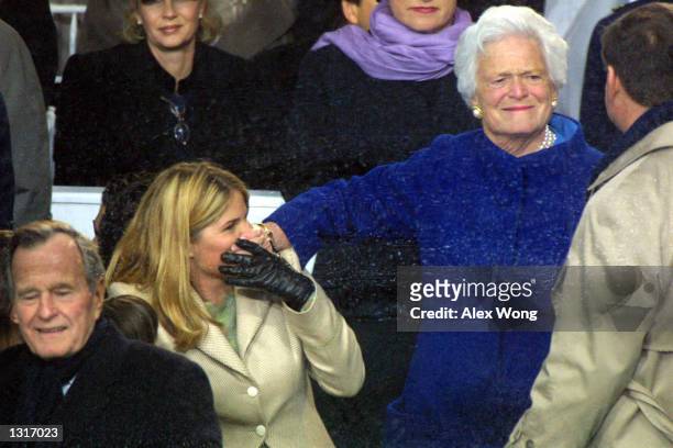 Former first lady Barbara Bush uses her hand to cover her granddaughter Jenna''s mouth as she chats with a guest during the Inaugural Parade January...
