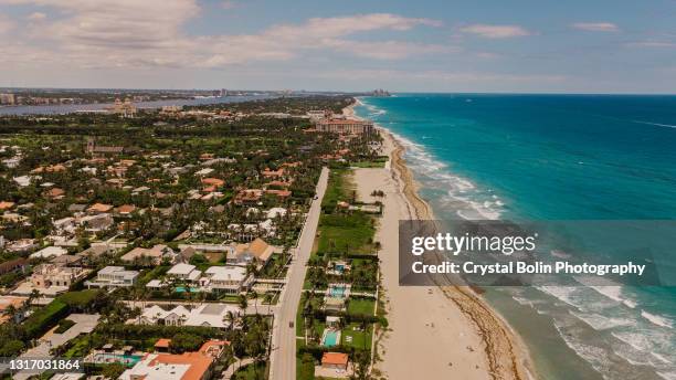vista aérea de uma costa marítima vibrante teal oceânica cheia de guarda-chuvas coloridos de praia em palm beach, flórida no meio do dia durante o covid-19 em maio de 2021 - condado-de-palm-beach - fotografias e filmes do acervo