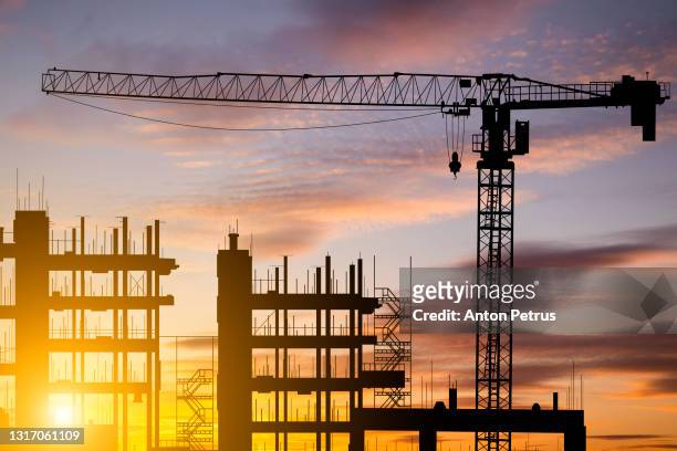 construction site with cranes at sunset. construction of an apartment building - strong foundations stock pictures, royalty-free photos & images