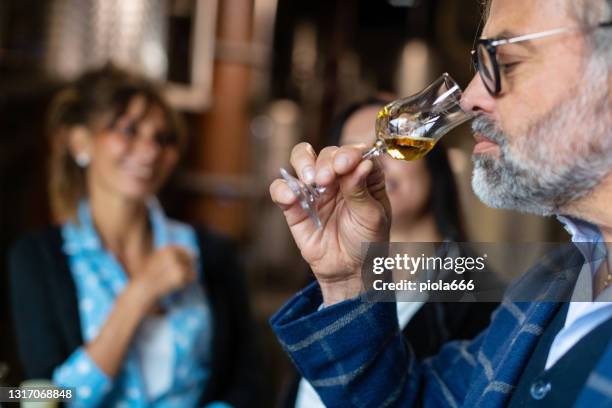 wijnproeverij in een italiaanse wijnmakerij na het oogsten van druiven: grappa drinken - grappa stockfoto's en -beelden