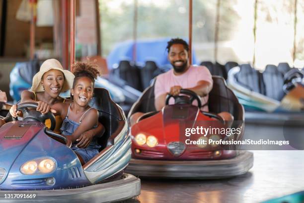 fröhliche mutter und tochter der afroamerikanischen ethnizität haben spaß im luna park. - autoscooter stock-fotos und bilder