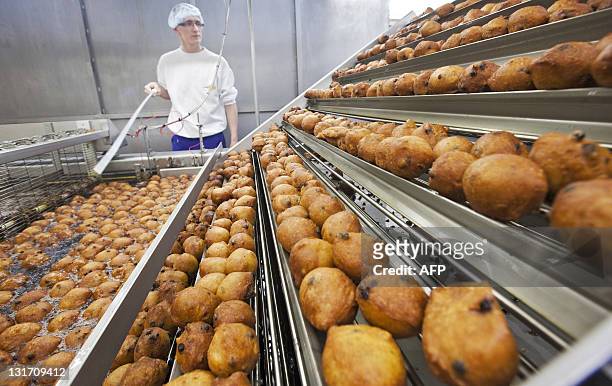 Worker oversees the production of traditional Dutch food known locally as 'oliebollen' at a bakery in Beverwijk, on November 7, 2011. The bakery...