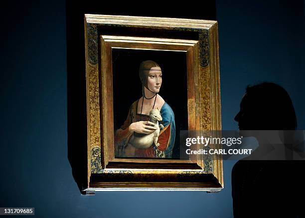 Woman poses for pictures beside a painting entitled 'Portrait of Cecilia Gallerani' by Italian artist Leonardo da Vinci during a photocall at the...