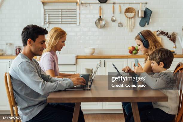 happy family using electronic device at home - mother and son using tablet and laptop stock pictures, royalty-free photos & images