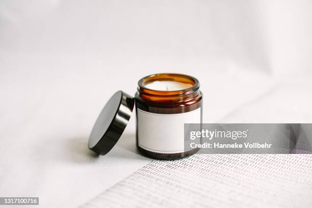 white label soy wax candle in apothecary jar with lid - vela encendida fotografías e imágenes de stock