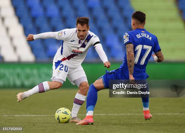 Rober of SD Eibar battles for possession with Mathias Olivera of Getafe CF during the La Liga Santander match between Getafe CF and SD Eibar at...