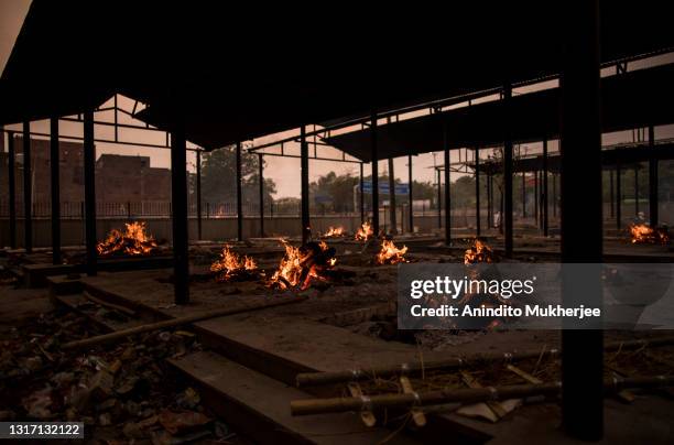 Multiple funeral pyres for the last rites of the patients who died of the Covid-19 coronavirus and other fatalities burn at a crematorium on May 09,...