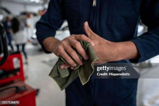 mechanic cleaning his hand with a cloth at the end of his shift - rag stock pictures, royalty-free photos & images