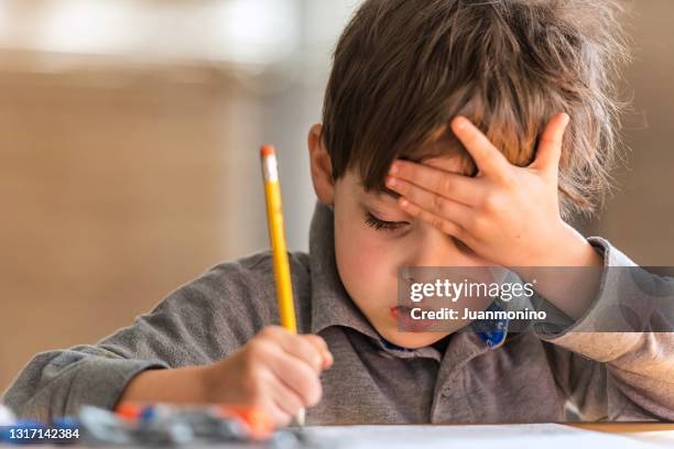 kleiner junge, der seine arbeit in einem vorschul-klassenzimmer macht - confused writing stock-fotos und bilder