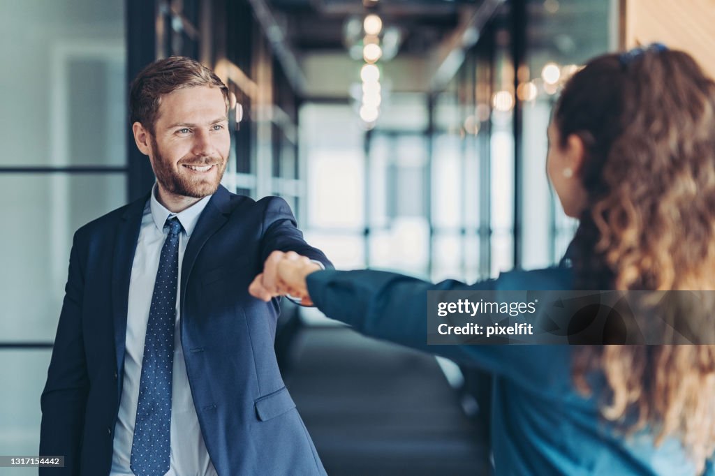 Business persons greeting with a fist bump