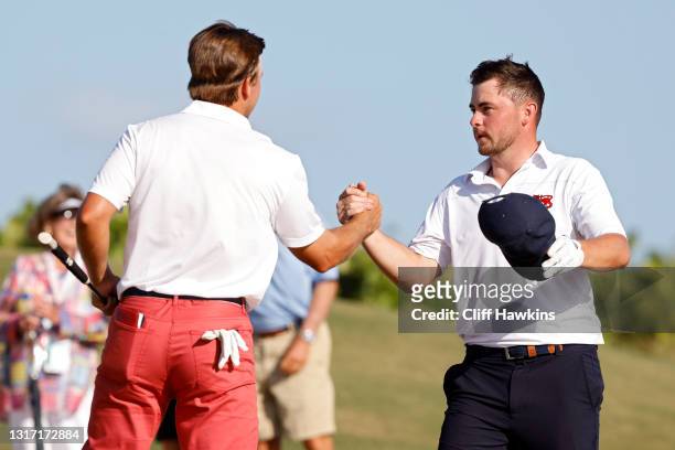Pierceson Coody of Team USA and Alex Fitzpatrick of Team Great Britain and Ireland shake hands on the 17th green after Coody won their match during...