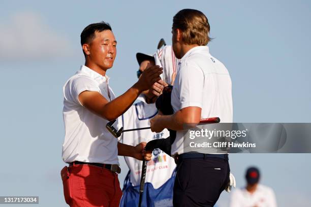 John Pak of Team USA and Joe Long of Team Great Britain and Ireland shake hands on the 18th green after Long won their match during Sunday singles...