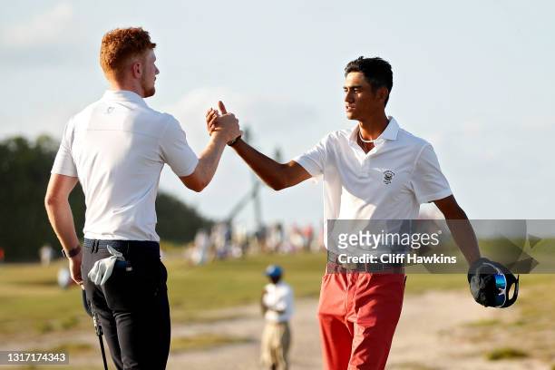 John Murphy of Team Great Britain and Ireland and Ricky Castillo of Team USA shake hands on the 17th green after Castillo won their match during...