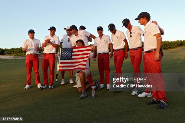 Members of Team USA pose for photos with a flag after defeating Team Great Britain and Ireland 14-12 during Sunday singles matches on Day Two of The...