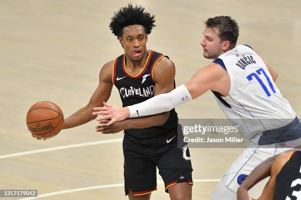 Collin Sexton of the Cleveland Cavaliers passes while under pressure from Luka Doncic of the Dallas Mavericks during the second quarter at Rocket...