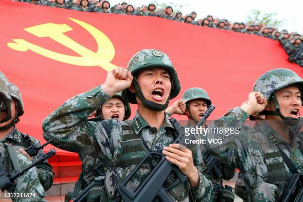 Members of the Communist Party of China review the oath of joining the party in front of the party flag on April 13, 2021 in Luoyang, Henan Province...