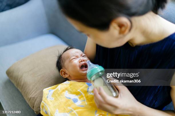 asian single mother  feeling noisy his newborn daughter crying and shouting at home after feeding and burped - crying sibling stock pictures, royalty-free photos & images